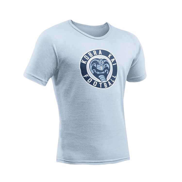 A light blue short-sleeve crewneck t-shirt featuring a circular navy blue graphic on the chest with a cobra snake and the text 'Kobra Kai Football'.